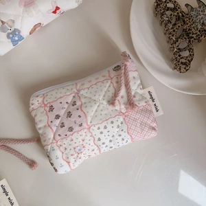 Detailed macro of a quilted floral mini pouch with a zipper closure and simple wish label