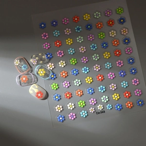 Macro detail of 3D candy-colored floral nail art stickers with embossed relief texture