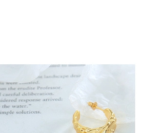 Macro detail of gold earrings featuring artistic lava texture and hollow geometric design