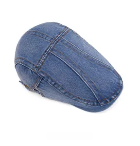 Top view of vintage blue washed denim beret with brown stitching and metal buckle