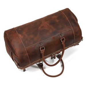 Macro view of dark brown crazy horse leather texture and stitching on travel duffle bag