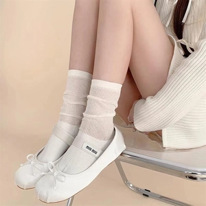 Nahaufnahme weißer, transparenter gerippter Socken mit flachen Ballerinaschuhen
