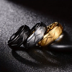 Three-piece grooved metal rings in black, gold and silver on black stones with matte finish
