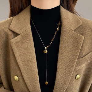 Vintage stainless steel Y-shaped necklace with tiger eye stone beads on a female model