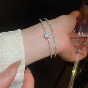 Close-up of double layered silver zircon bow bracelet set worn in an elegant setting