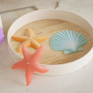 Macro shot of seashell and starfish shaped scented candles with realistic coral texture