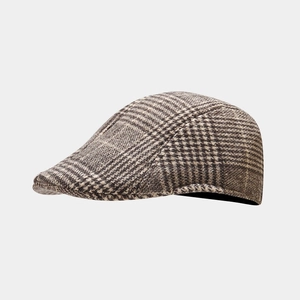 Close-up of vintage brown plaid flat cap showing premium wool texture and pattern