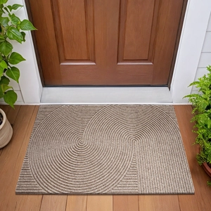Detail of non-slip entryway mat with brown spiral texture on elegant wooden floor