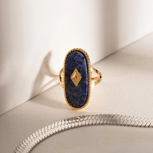 Détail macro d'une pierre de lapis-lazuli ovale sertie sur une bague vintage dorée