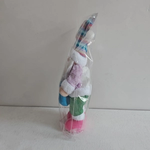 Detail of Christmas gnome plush doll with colorful knitted hat and purple velvet jacket
