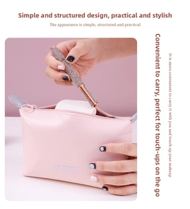 Detail of pink PU leather makeup bag with rose gold eyeliner pen and powder compact inside