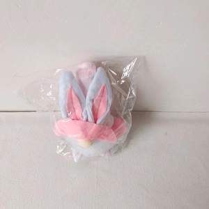Detailed view of pink plaid Easter gnome plush toy inside transparent plastic packaging