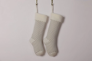 Detail of beige and light gray striped knitted Christmas stockings with hanging loops
