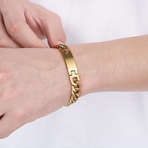 Close-up of a person wearing a polished gold stainless steel curved bar chain bracelet
