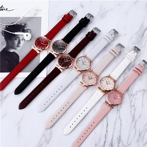Flat lay of stylish women's quartz watches with leather straps on marble background