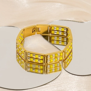 Detailed macro of gold-plated stainless steel bracelet with yellow and clear beads