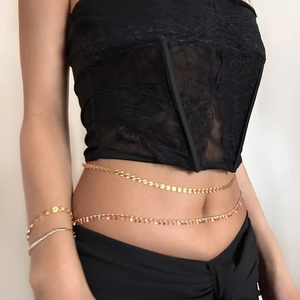 Detail of multilayered 18k gold plated waist chain with colored beads and sequins