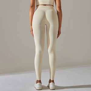 Détail du tricot sans couture et de l'effet galbant sur le legging de yoga de couleur crème