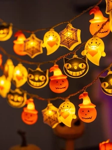 Close-up of LED pumpkin and ghost string lights glowing with warm festive orange light