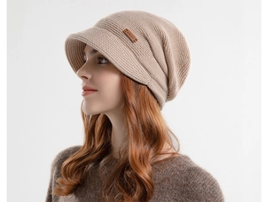 Detailweergave van de beige gebreide muts met zachte voering en decoratief merklabel