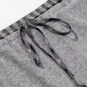 Detail of grey knit elastic waistband with plaid drawstring on skirt and top set