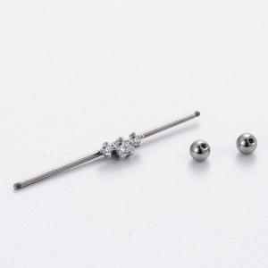 Detail of silver piercing jewelry parts with clear gemstones and threaded metal balls