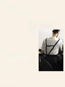 Détail du tablier noir avec bretelles en H et design ajusté à la taille pour un look élégant