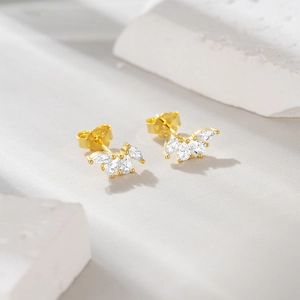 Detailed macro view of S925 sterling silver gold leaf earrings with sparkling zircon stones