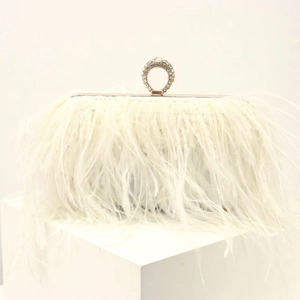 Detail of cream evening clutch with lush ostrich feathers and crystal-encrusted ring handle