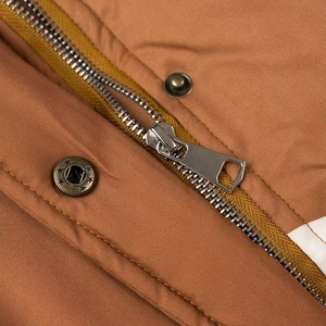 Makroaufnahme von silbernem Reißverschluss und bronzenen Druckknöpfen der Jacke