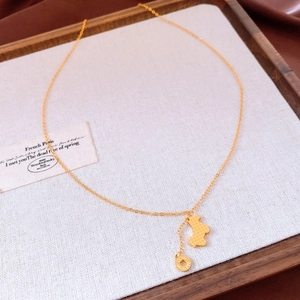 Close-up of gold-plated bear pendant with textured finish on a minimalist chain