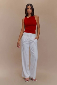 Top aderente smanicato con scollo a V rosso scuro e pantaloni larghi bianchi in lino a pieghe