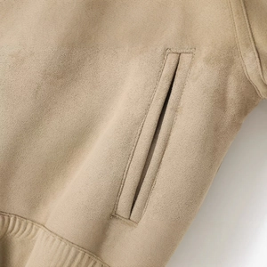 Détails de la veste en similicuir kaki montrant la poche et l'ourlet côtelé fin