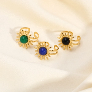 Vintage stainless steel sun-shaped open rings with turquoise stones on silk background