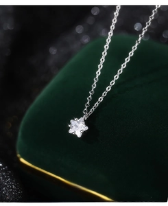 Close-up of S999 silver star zircon pendant necklace on a green velvet jewelry box