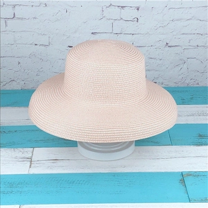 Detail showing the fine woven texture and flat brim of a pink summer straw hat