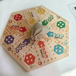 Top view of a hexagonal wooden board game with colorful paths and a linen storage bag