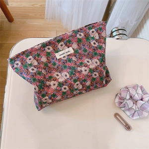 Detailed macro of vintage floral cotton makeup bag with white simple wish label