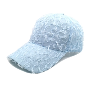 Detailed close-up of light blue baseball cap with unique feather-like frayed texture