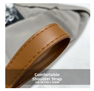 Detail of comfortable brown leather shoulder strap with durable stitching and texture