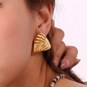 Close-up of 18K gold plated stainless steel triangle stud earrings with striped texture