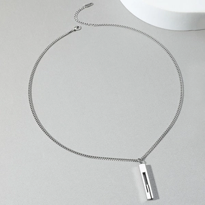 Minimalist silver stainless steel necklace with rectangle pendant on light gray background
