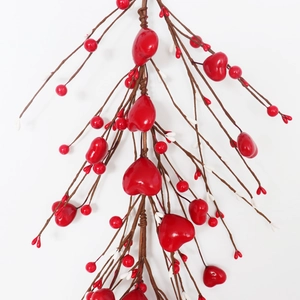Close-up of artificial red heart berries and white buds on decorative branches