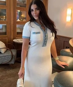 Close-up of white ribbed knit dress with blue contrast trim and metallic button detail