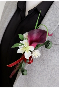 Detail of burgundy calla lily boutonniere with white flowers on a grey wool blazer lapel