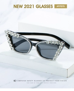 Detail of black cat eye sunglasses with shimmering rhinestones and crystal chain accents