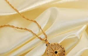 Detailed macro of gold octagonal star pendant with black gem on silk background