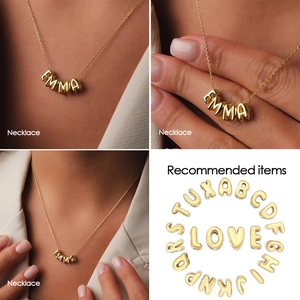 Detailed views of gold puffy initial charms and personalized EMMA name necklace on model