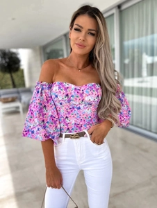 Detailed view of off-shoulder floral blouse with puff sleeves and pink floral pattern