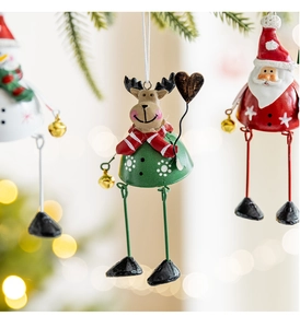 Close-up of metal Santa, Reindeer, and Snowman ornaments hanging on a Christmas tree